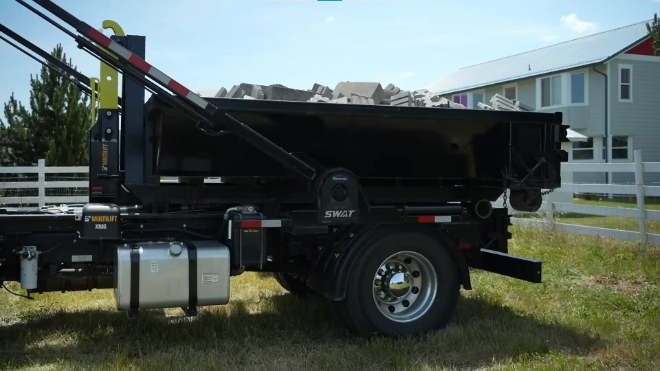 A dumpster loaded on a trailer for delivery in Owensboro KY